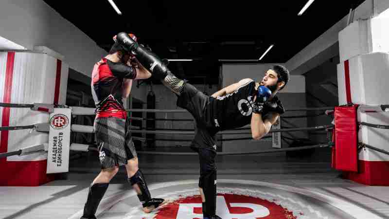 Intense kickboxing match between two athletes in training gear inside a professional ring., tags: die kickboxen - pexel